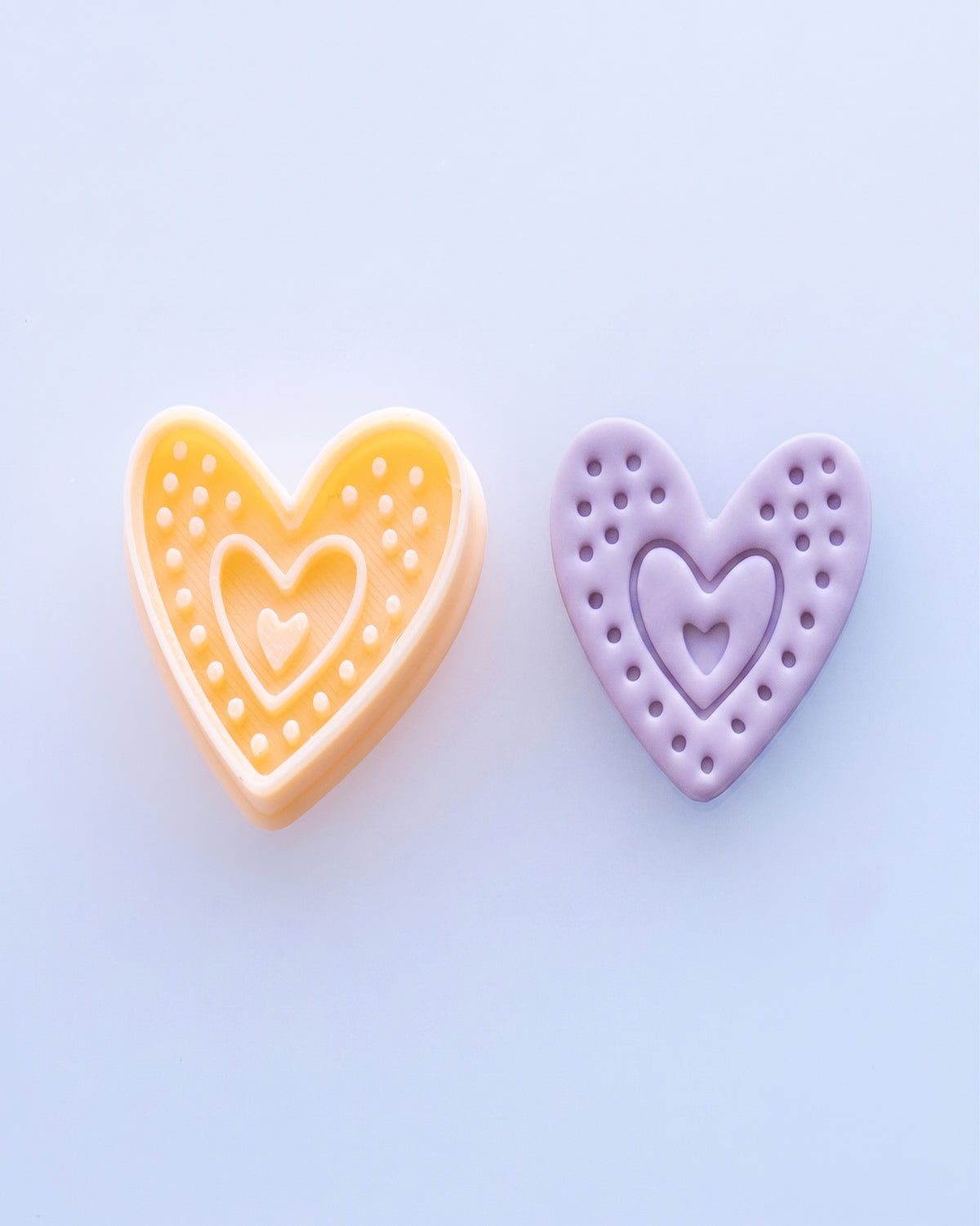 Close view of the Boho Dotted Heart cutter beside a matching purple clay imprint, showing the heart silhouette, dotted border and layered center detail.
