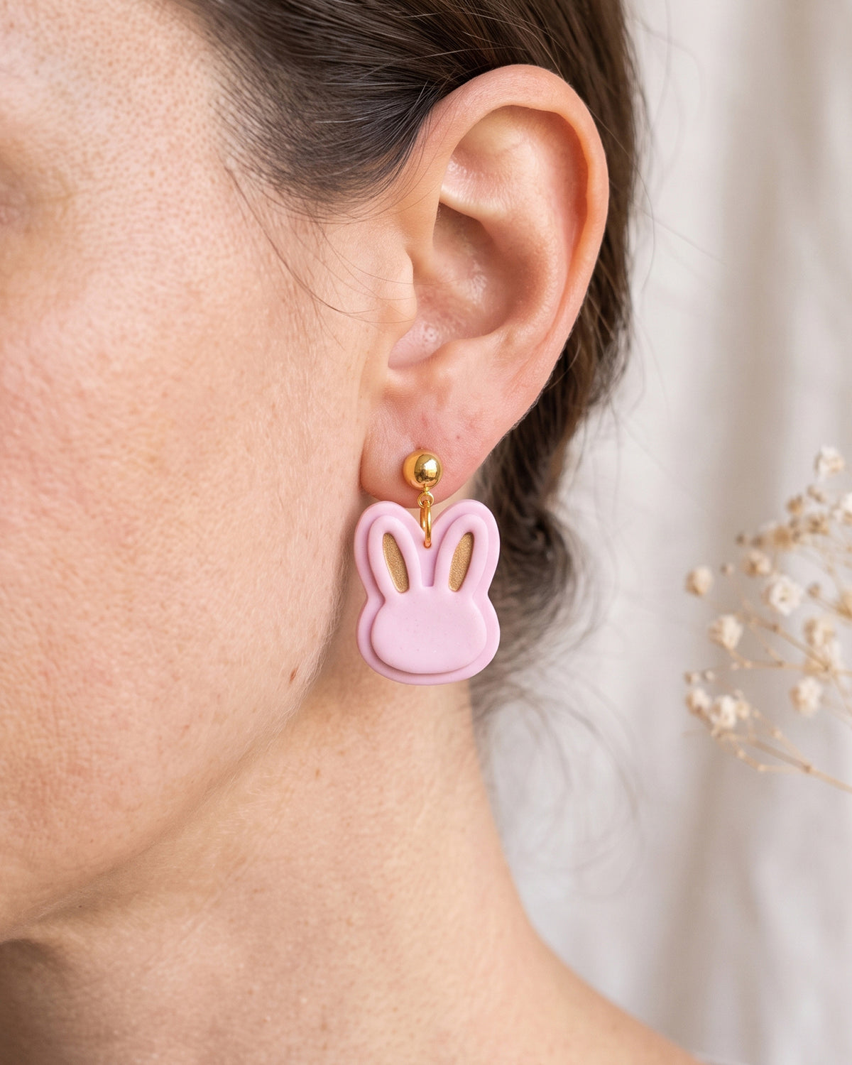 A model wearing finished Mini Bunny Head polymer clay jewelry, showing its appearance and scale when worn.