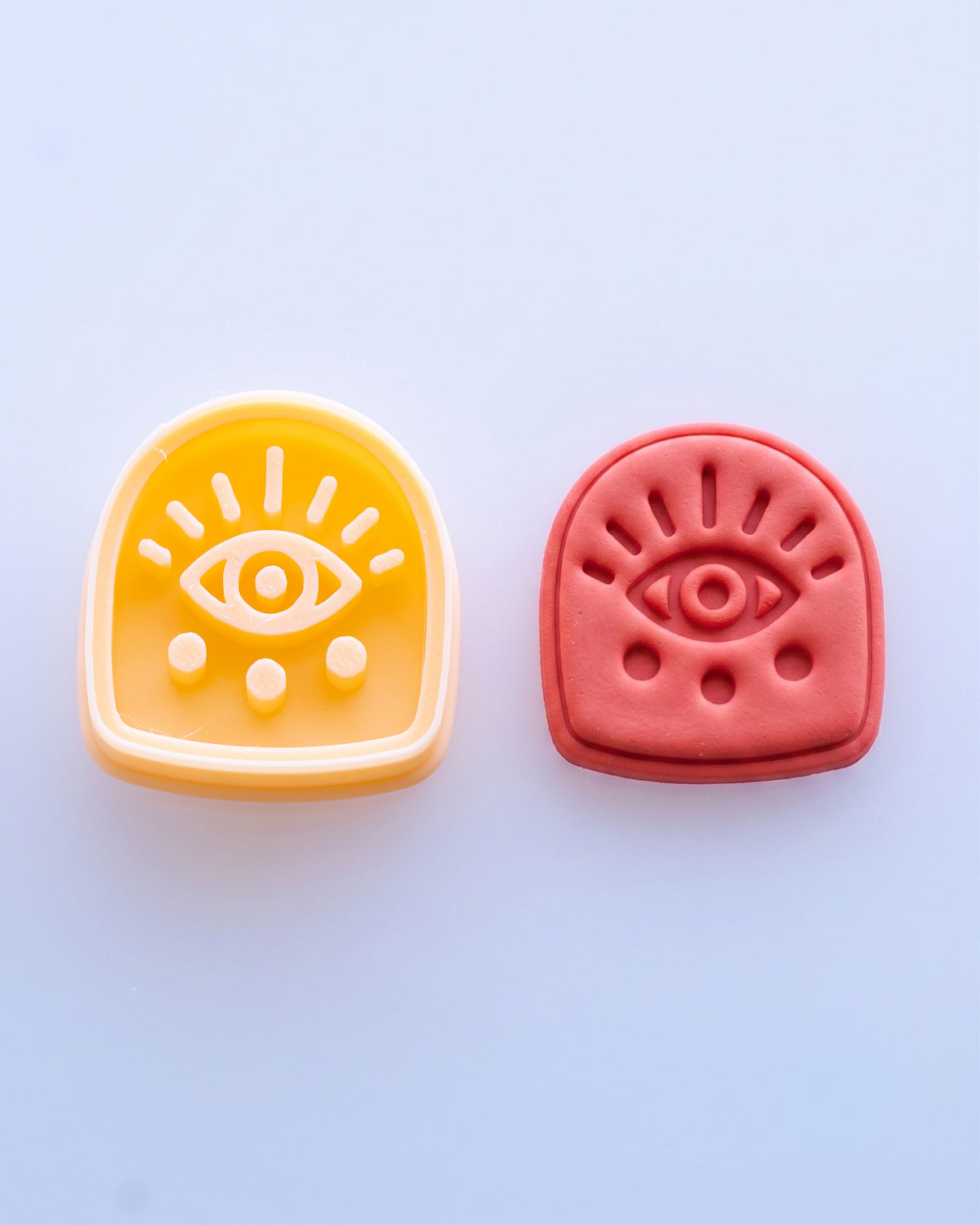 Close product view showing the printed Boho Eye Arch clay cutter beside its matching polymer clay imprint.