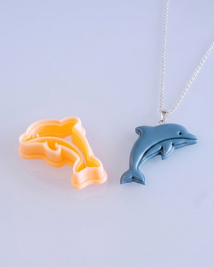 Close product view showing the printed Dolphin clay cutter beside its matching polymer clay imprint.