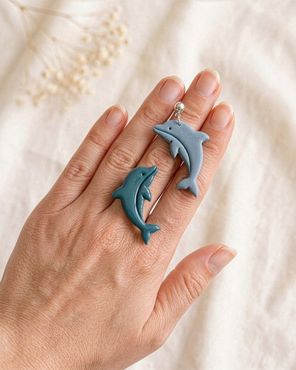 Hand-scale photograph showing the relative size of a finished Dolphin polymer clay piece.