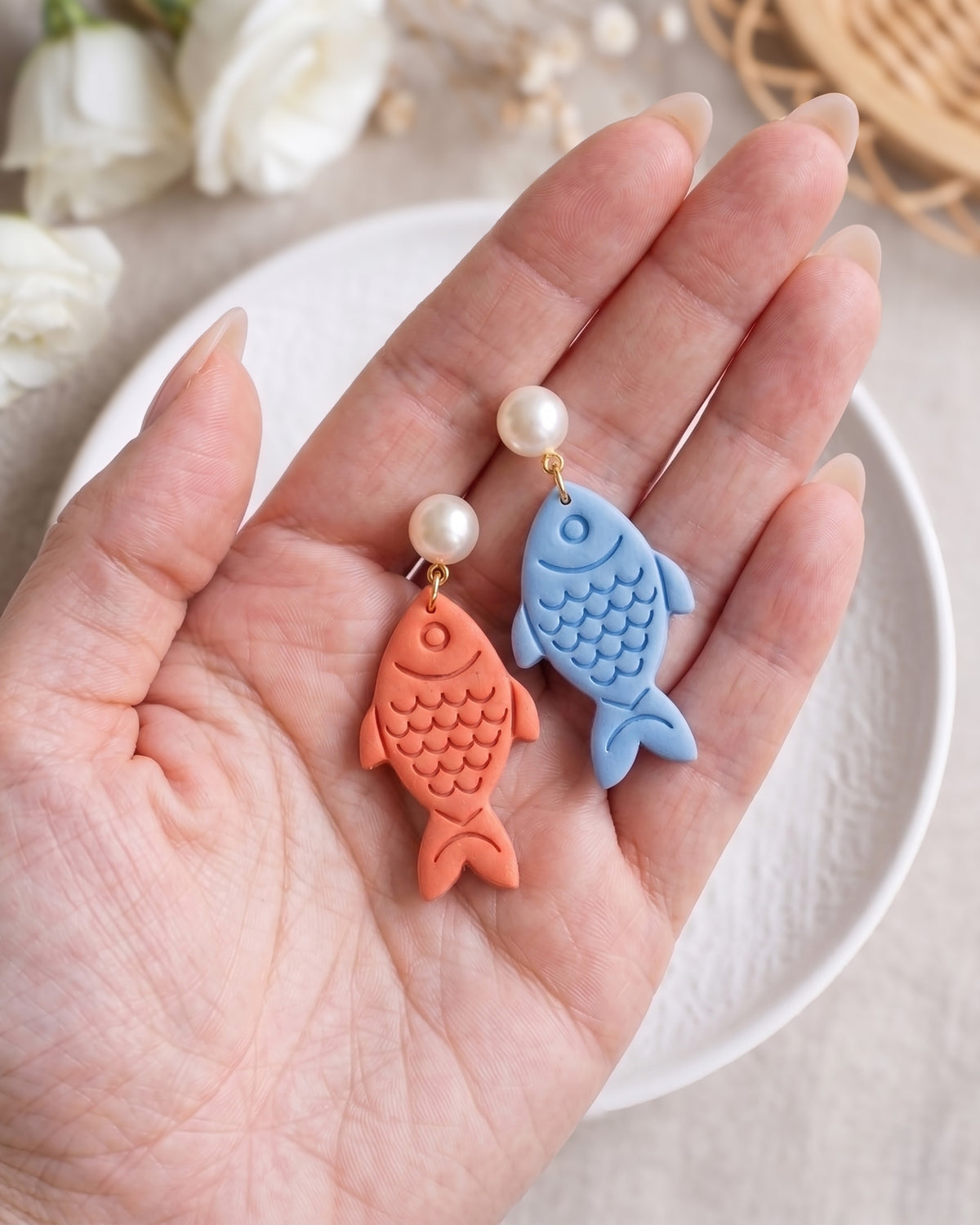 Hand-scale photograph showing the relative size of a finished Fish polymer clay piece.