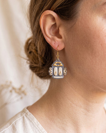 A model wearing finished Nordic Folk Lantern polymer clay jewelry, showing its appearance and scale when worn.