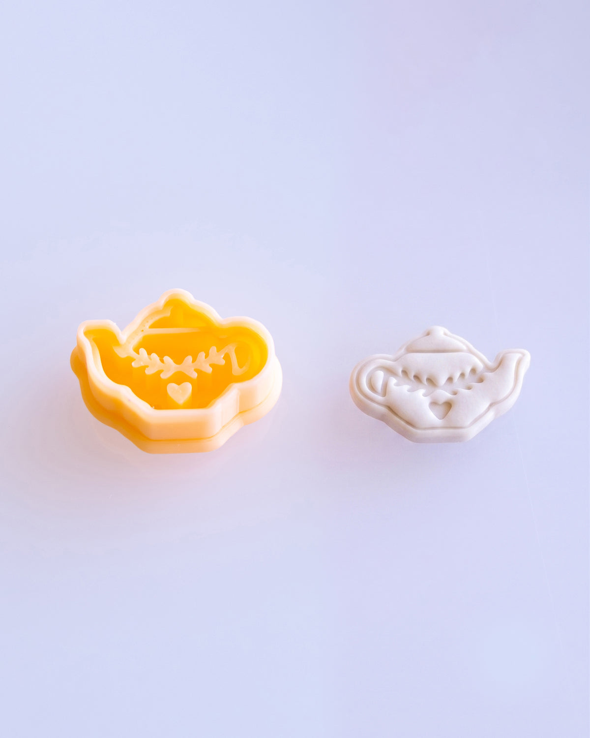 Close product view showing the printed Nordic Folk Teapot clay cutter beside its matching polymer clay imprint.