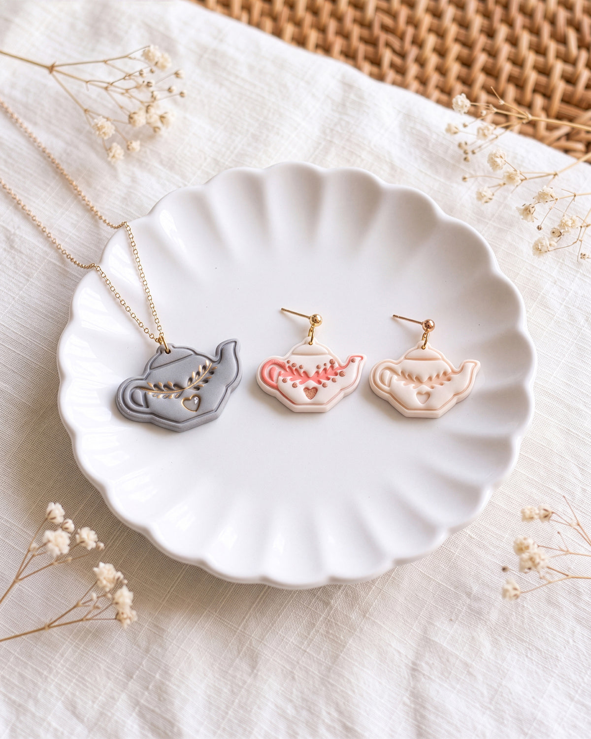 Styled lifestyle scene featuring the Nordic Folk Teapot cutter and finished polymer clay jewelry made with the design.