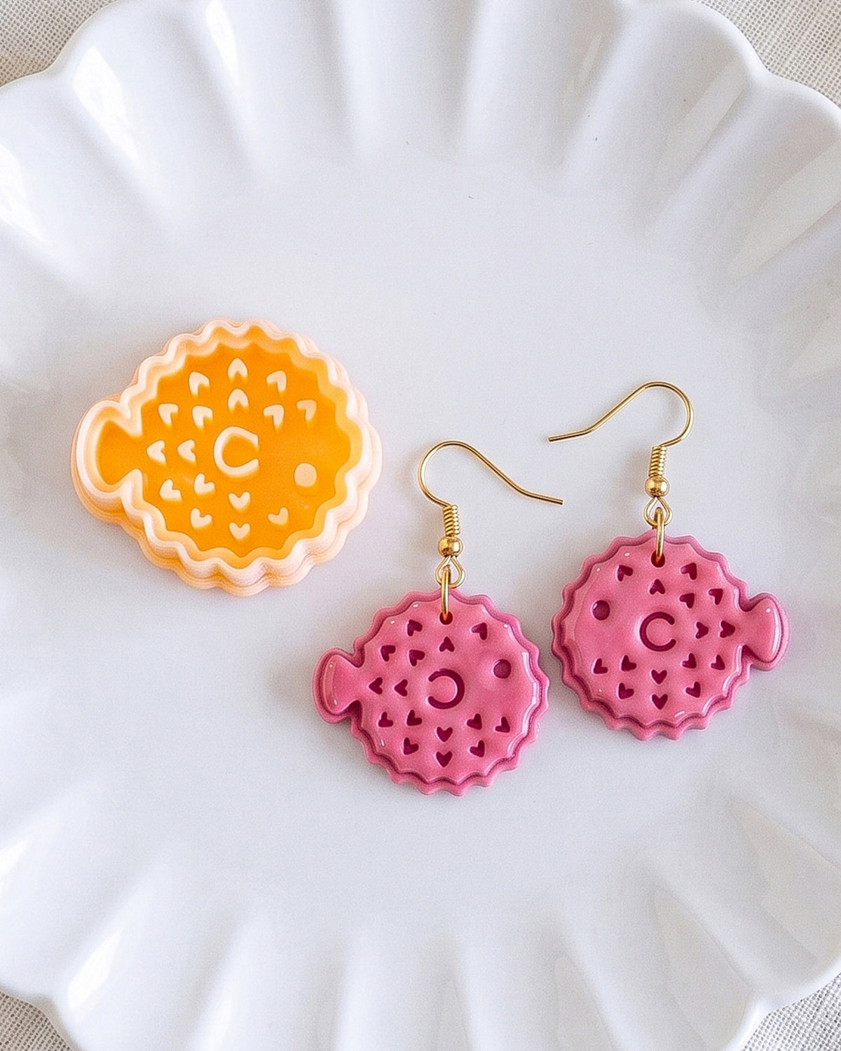 Close product view showing the printed Pufferfish clay cutter beside its matching polymer clay imprint.