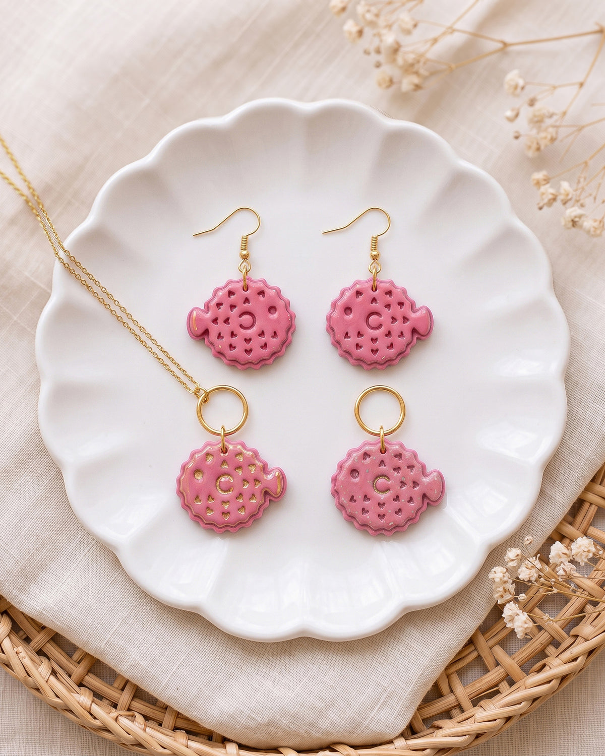 Styled lifestyle scene featuring the Pufferfish cutter and finished polymer clay jewelry made with the design.