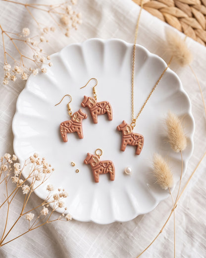 Close view of finished polymer clay jewelry made with the Scandi Dala Horse cutter design.