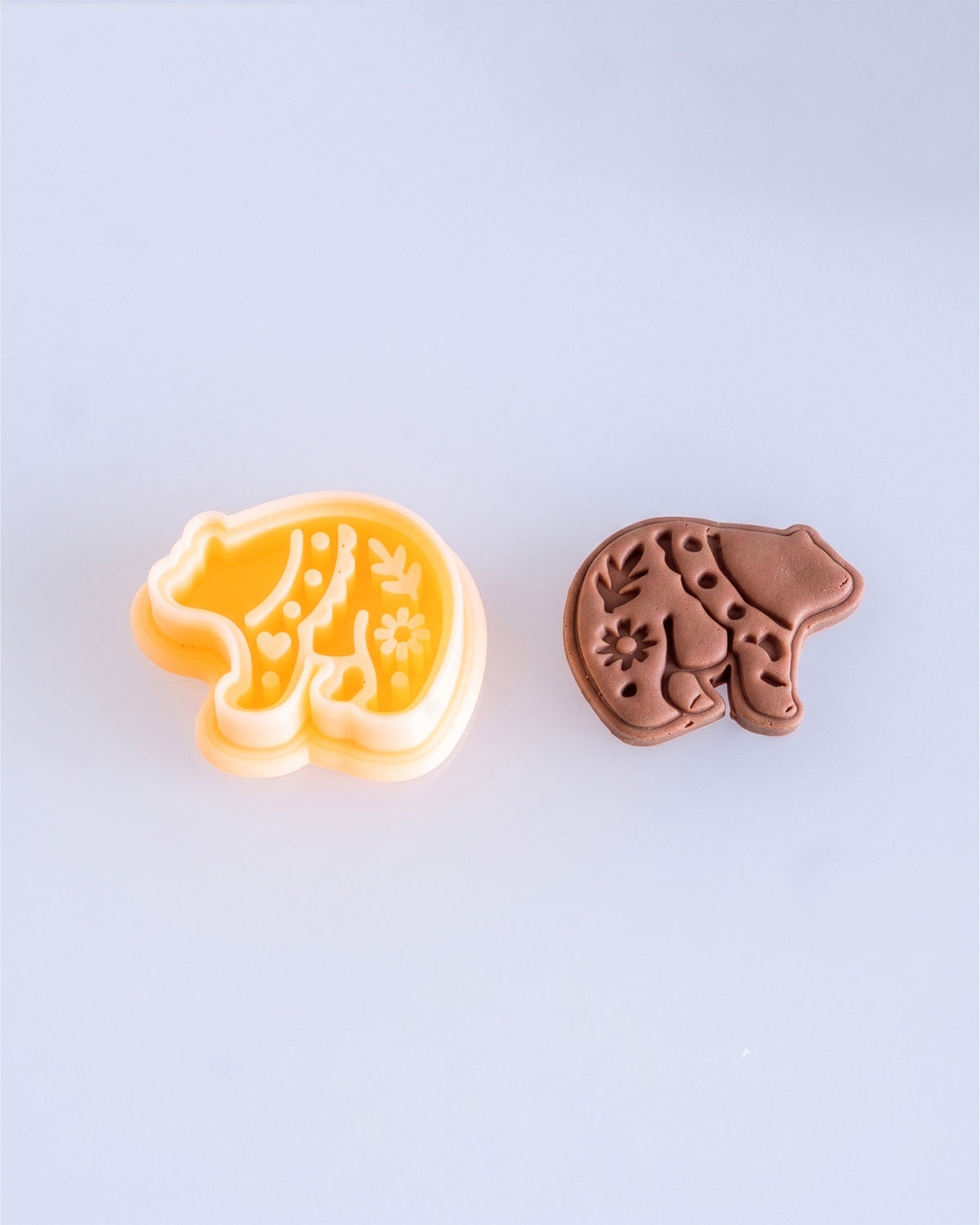 Close product view showing the printed Scandi Folk Bear clay cutter beside its matching polymer clay imprint.