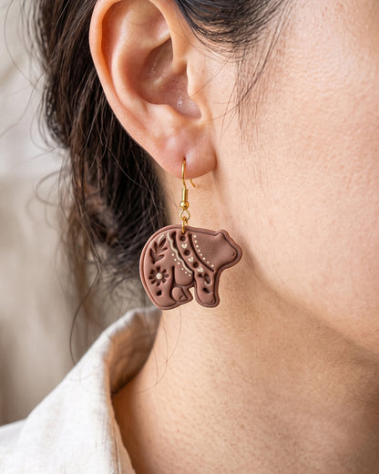A model wearing finished Scandi Folk Bear polymer clay jewelry, showing its appearance and scale when worn.