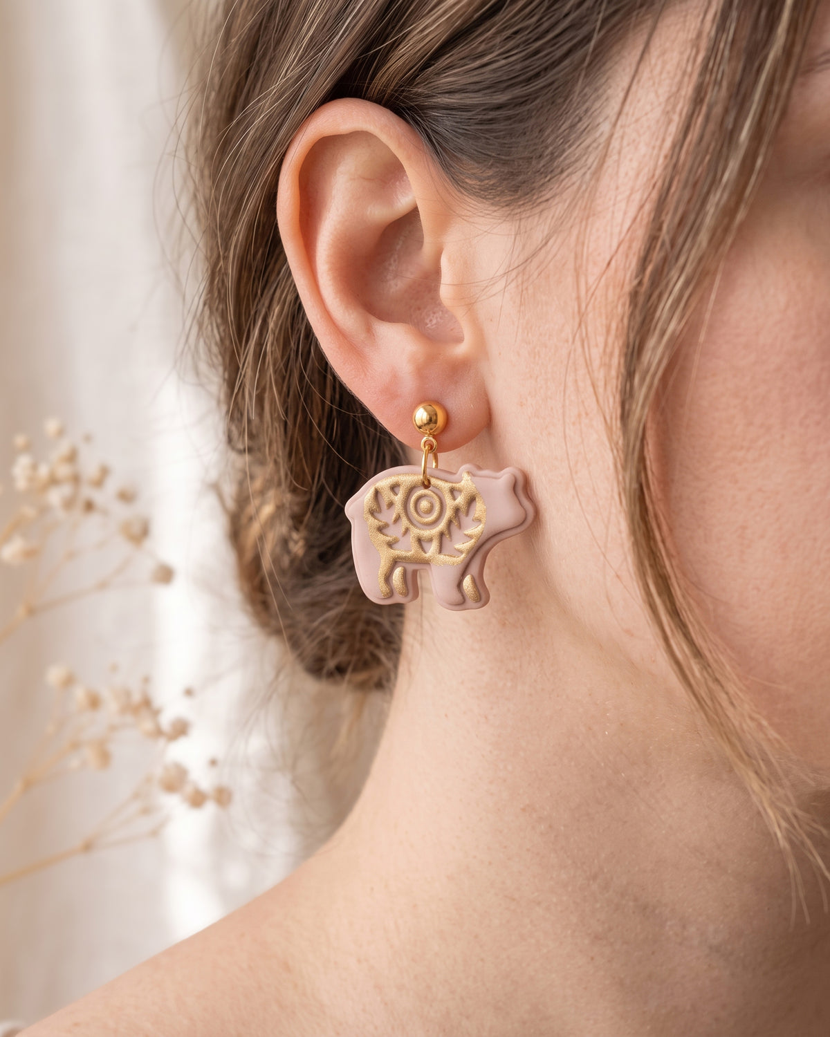 A model wearing finished Scandi Folk Bear (Woodland Collection) polymer clay jewelry, showing its appearance and scale when worn.