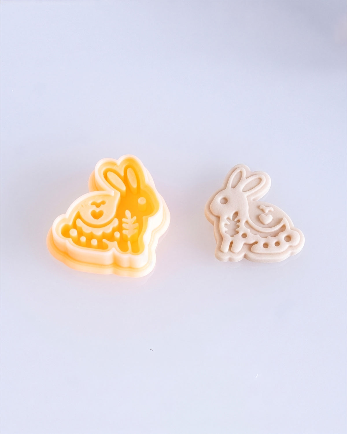 Close product view showing the printed Scandi Folk Bunny clay cutter beside its matching polymer clay imprint.
