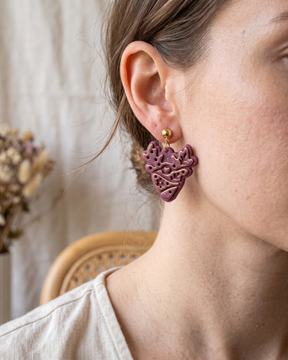 A model wearing finished Scandi Folk Deer Antlers polymer clay jewelry, showing its appearance and scale when worn.