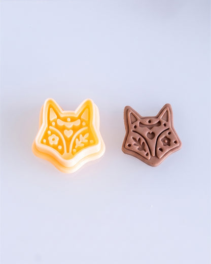 Close product view showing the printed Scandi Folk Fox Head clay cutter beside its matching polymer clay imprint.