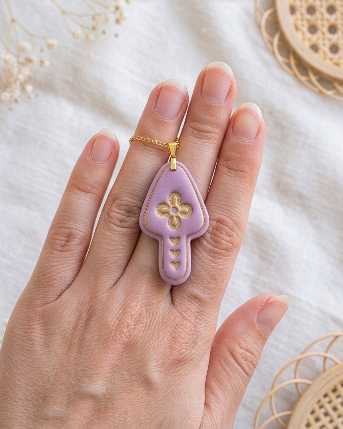 Hand-scale photograph showing the relative size of a finished Scandi Folk Heart Mushroom polymer clay piece.