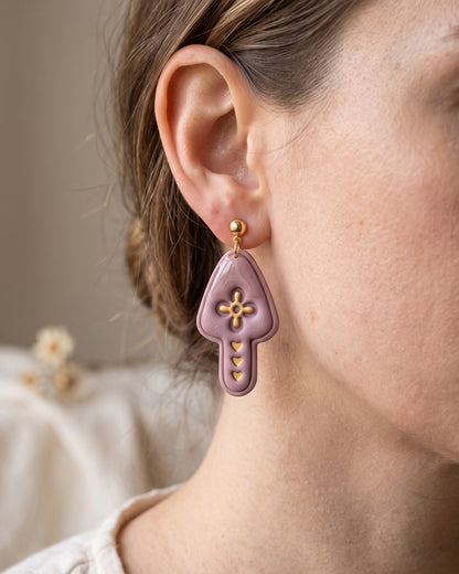 A model wearing finished Scandi Folk Heart Mushroom polymer clay jewelry, showing its appearance and scale when worn.