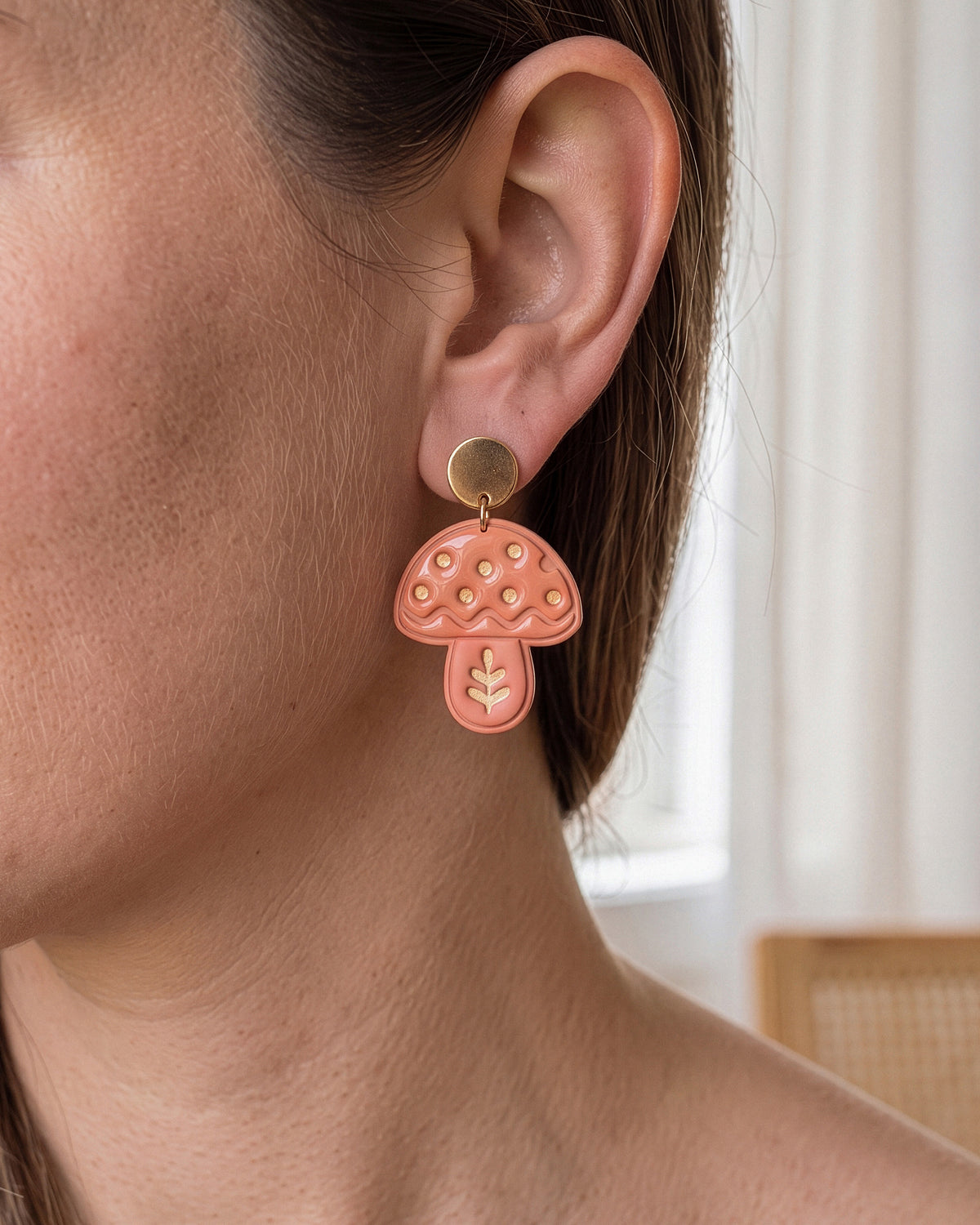A model wearing finished Scandi Folk Leaf Mushroom polymer clay jewelry, showing its appearance and scale when worn.