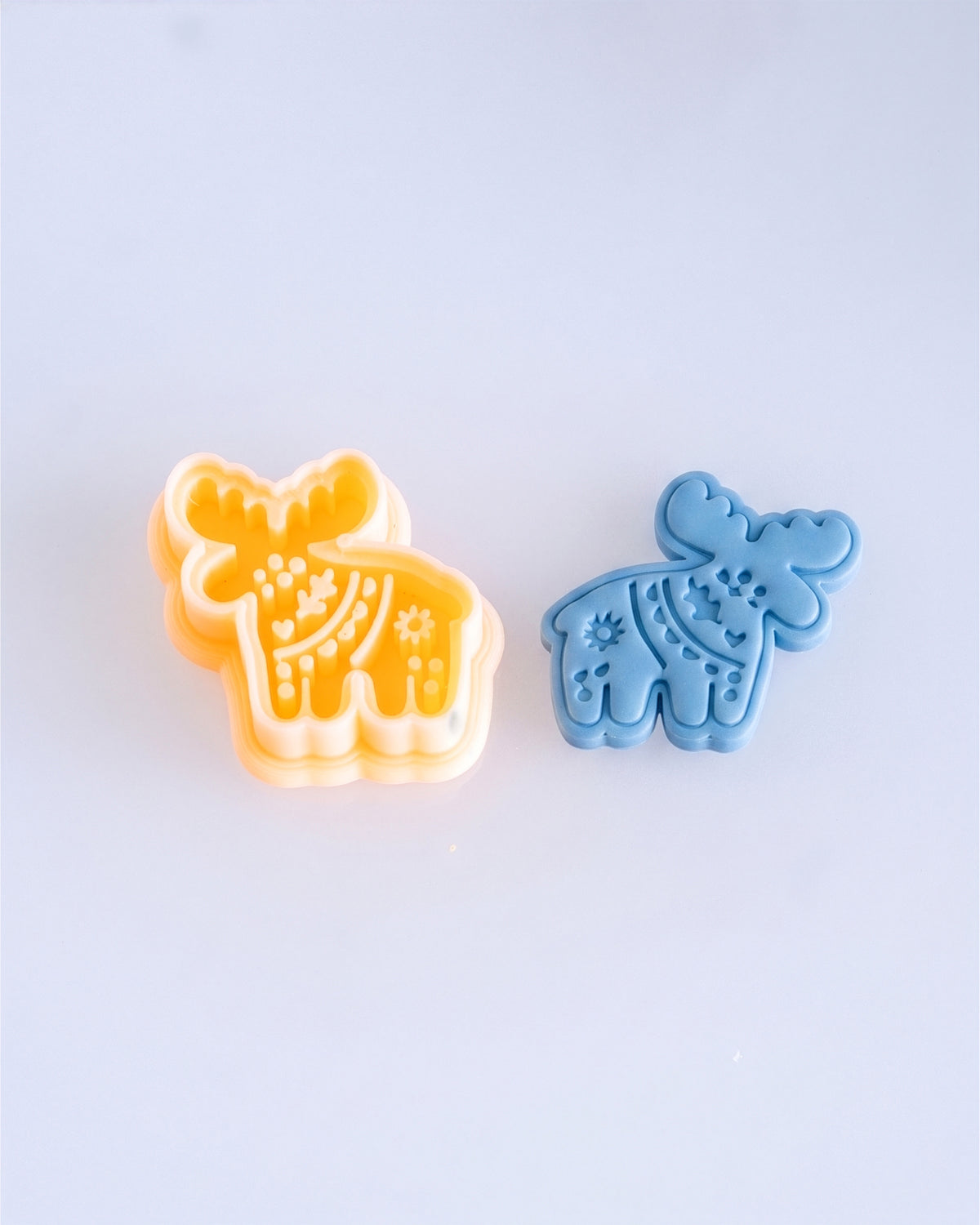 Close product view showing the printed Scandi Folk Moose clay cutter beside its matching polymer clay imprint.