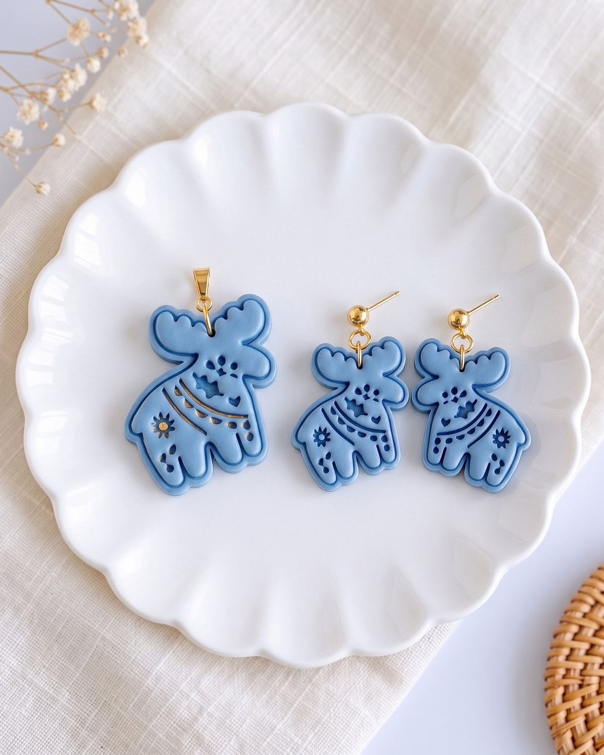 Styled lifestyle scene featuring the Scandi Folk Moose cutter and finished polymer clay jewelry made with the design.