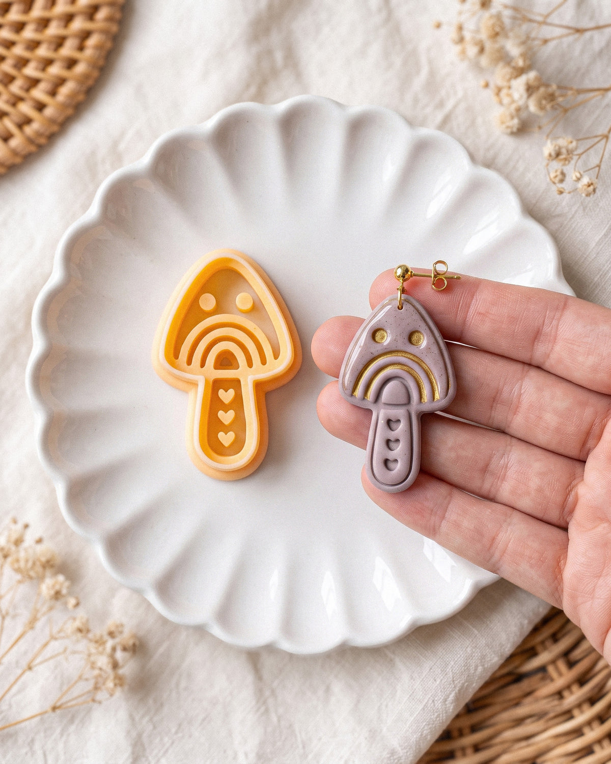 Hand-scale photograph showing the relative size of a finished Scandi Folk Rainbow Mushroom polymer clay piece.
