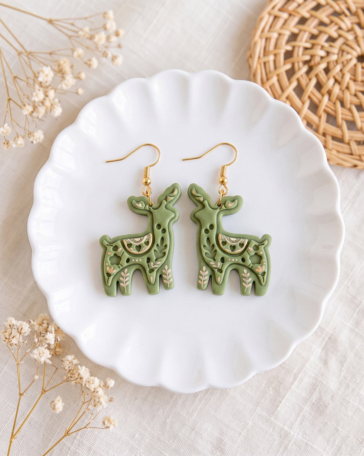 Styled lifestyle scene featuring the Scandi Folk Reindeer cutter and finished polymer clay jewelry made with the design.