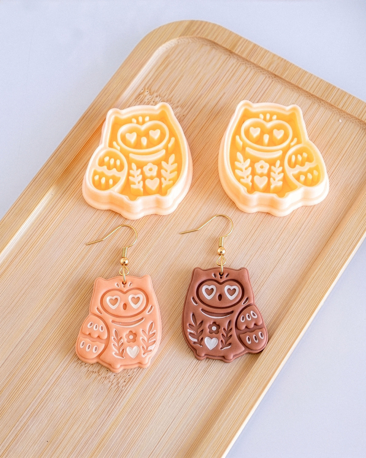 Styled lifestyle scene featuring the Scandi Owl cutter and finished polymer clay jewelry made with the design.